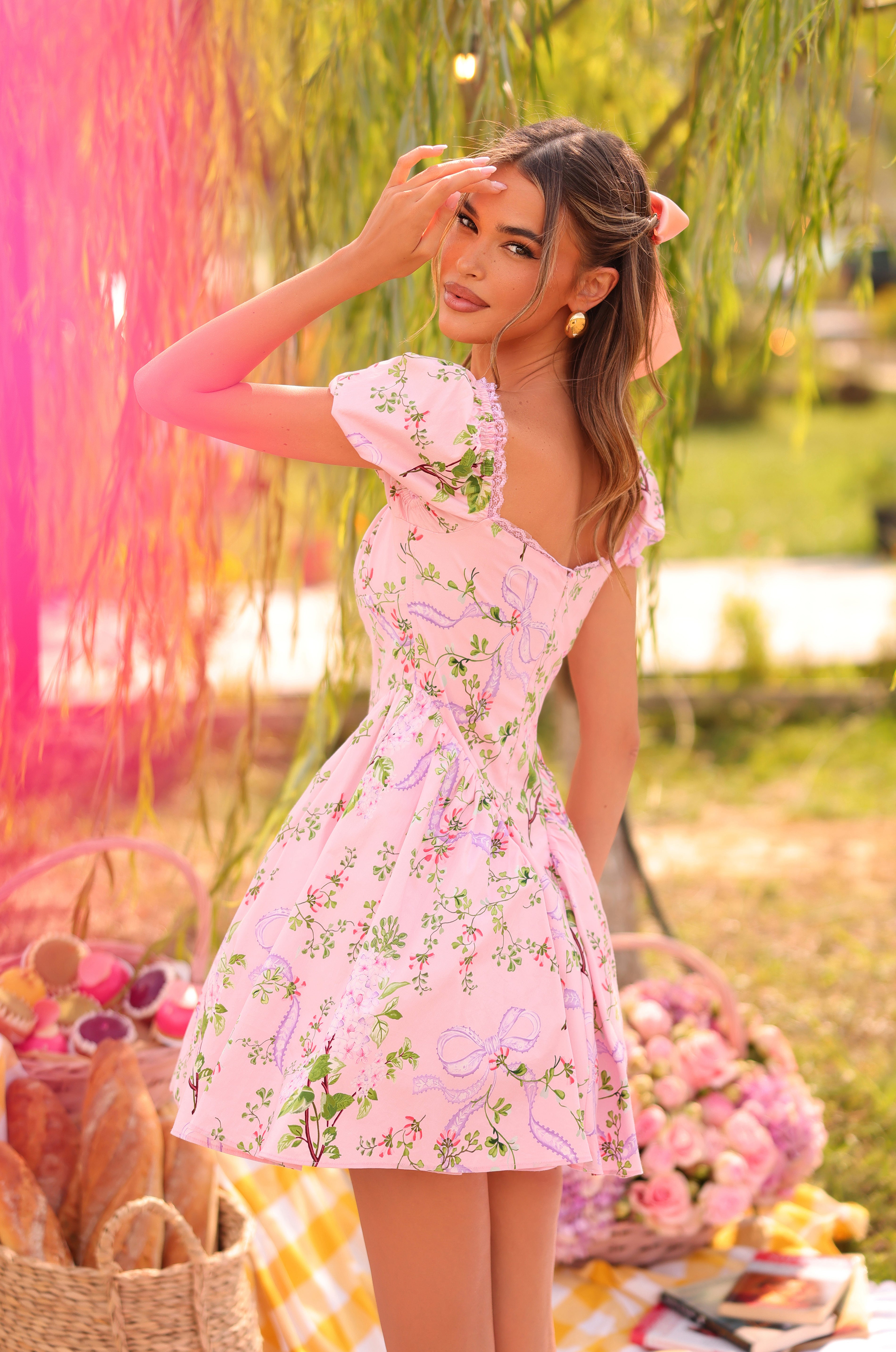 Pink floral puff-sleeve mini dress on model outdoors