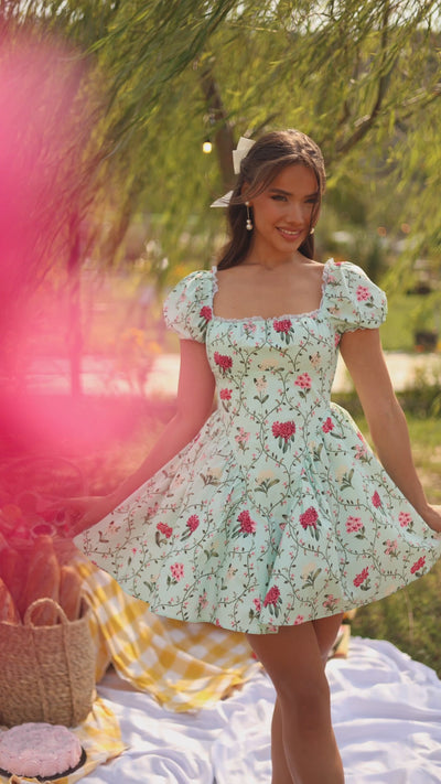 Mint green floral puff-sleeve mini dress on model outdoors